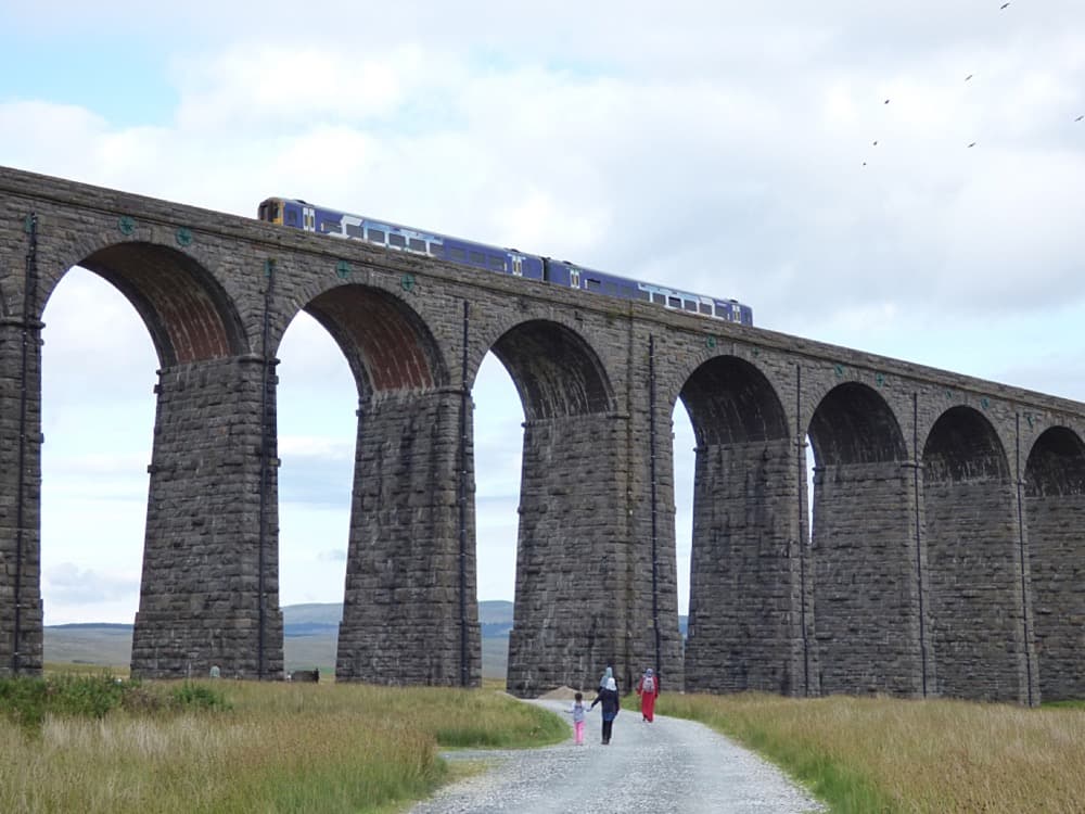 A train crossing Ribblehead Viaduct beneath a blue sky